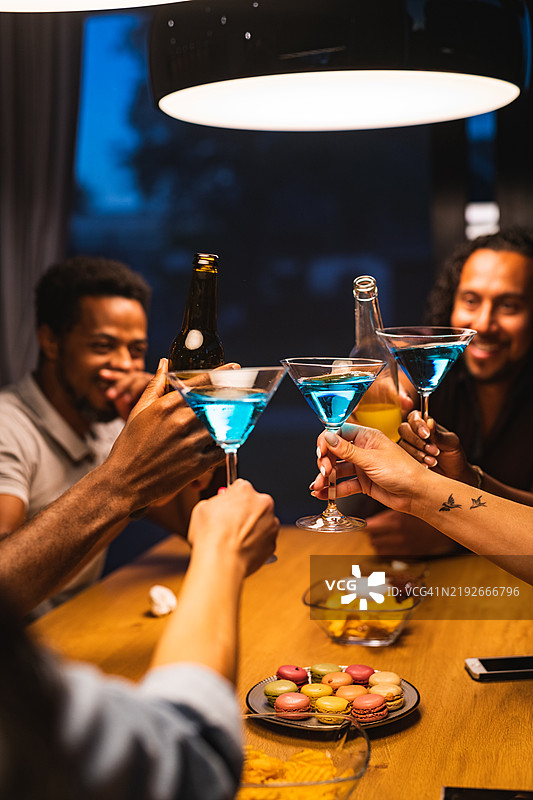 三杯蓝色马提尼酒在休闲会议中对齐并举起到中心位置图片素材