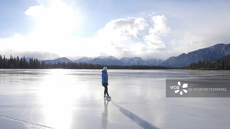 女人在冰冻的湖面上滑冰图片素材