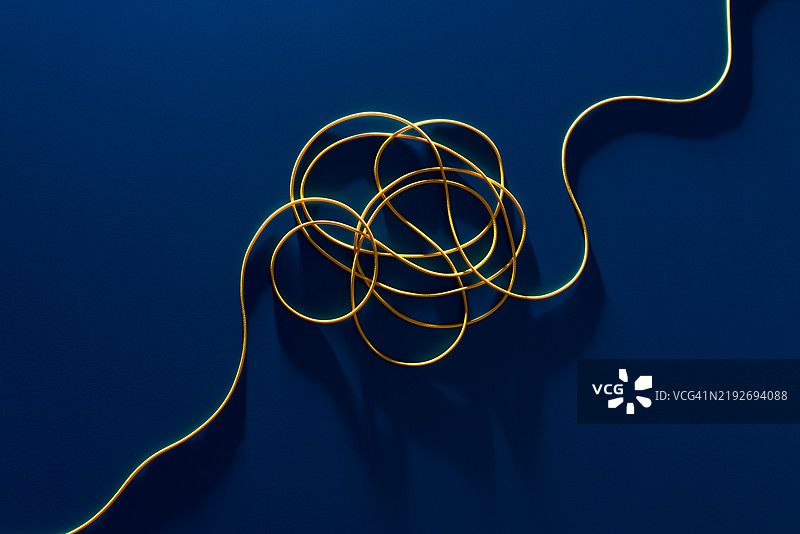 蓝色背景上的黄色绳索缠结成结图片素材