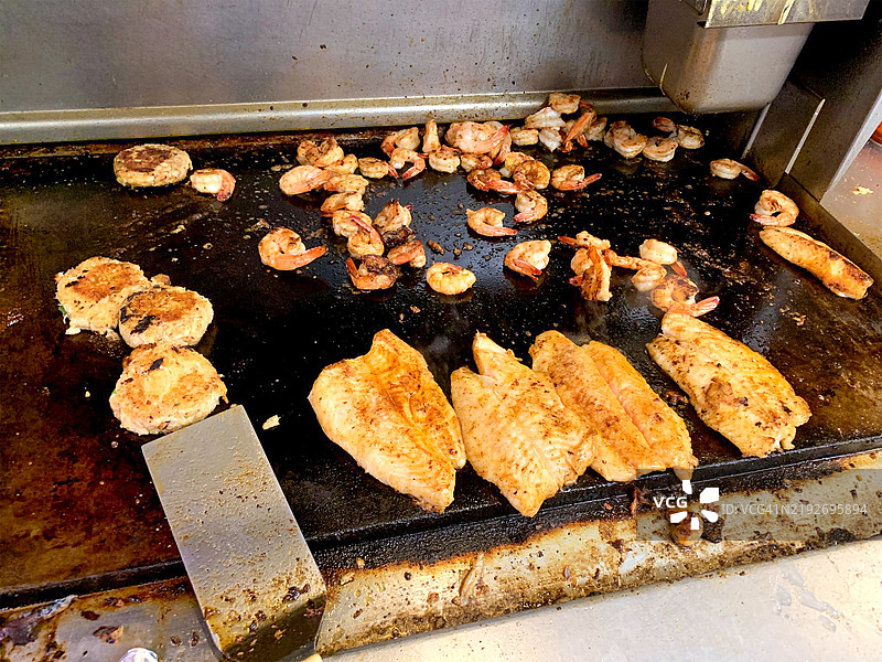 新鲜的虾和鱼在烤盘上烤制图片素材