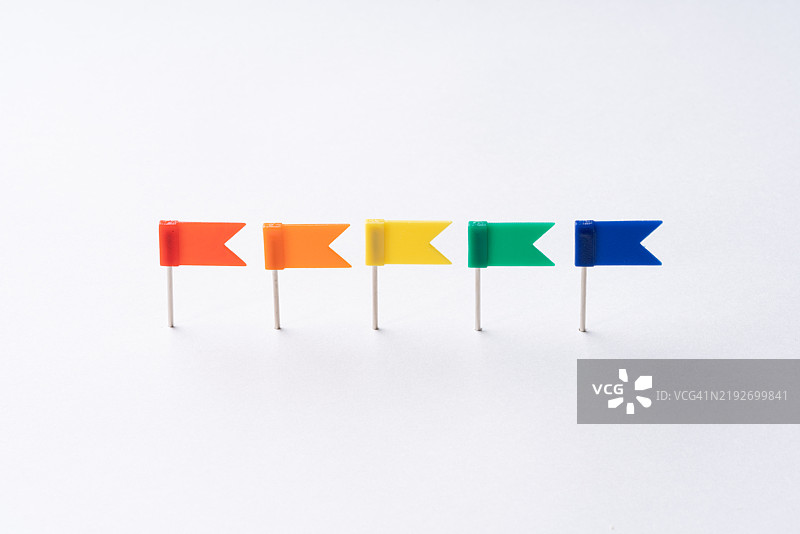 多色地图旗推针在白色背景上排成一行图片素材