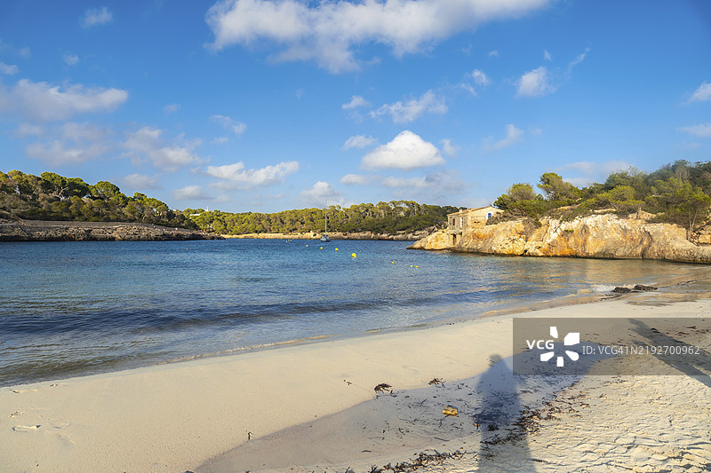 宁静的碧绿色海水轻轻拍打着西班牙马洛卡的萨马拉多尔海滩的白色沙滩，是一个完美的夏季度假胜地。图片素材