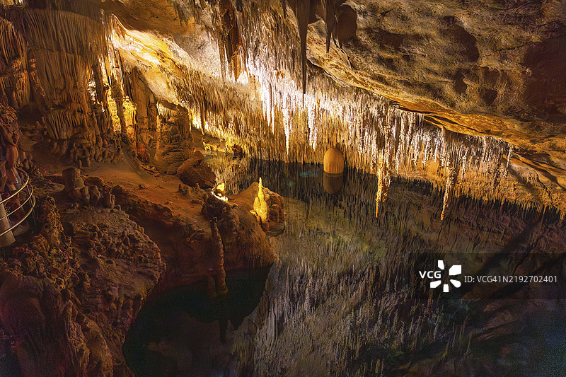 美丽的钟乳石在西班牙马洛卡的德拉赫洞穴中的马特尔湖上反射。图片素材