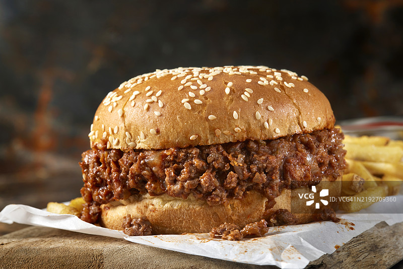 芝麻种子面包上的野牛肉松饼三明治配薯条图片素材