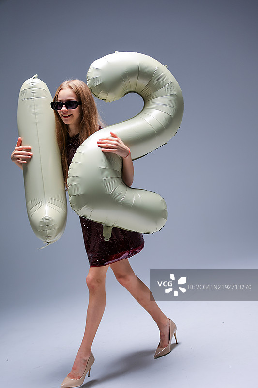 时尚模特展示充气数字，身穿时尚引人注目的服装图片素材