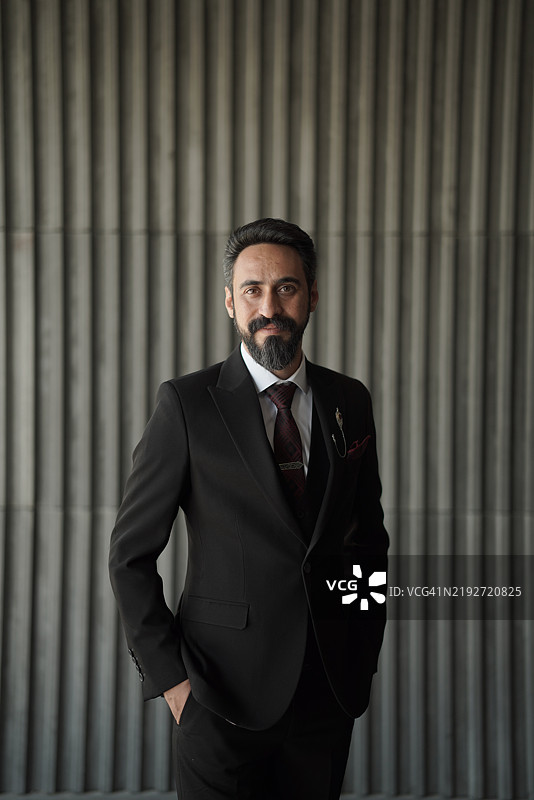 帅气的新郎靠在墙上拍婚纱照图片素材