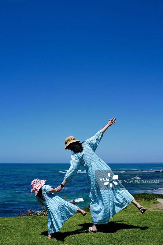 加利福尼亚州，美国，母女俩在海滩上背对着站立。图片素材