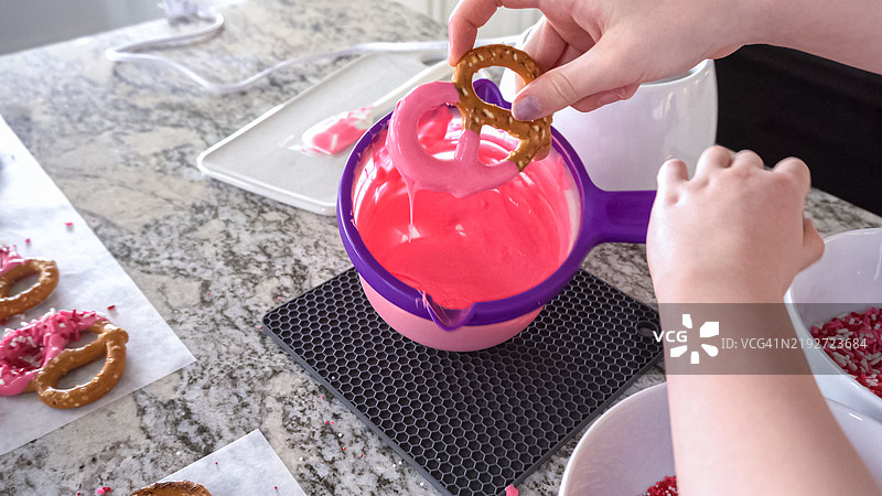 年轻厨师在阳光明媚的厨房里准备巧克力覆盖的美味点心图片素材