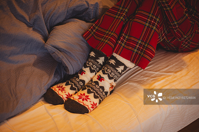 床上节日气氛浓厚的袜子特写，搭配一杯温暖的茶。图片素材