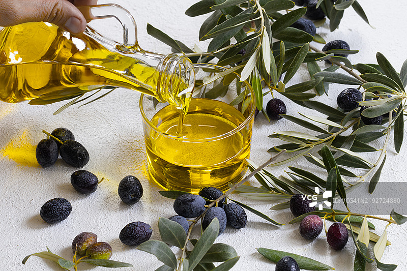 橄榄植物特写，桌上有生橄榄和叶子图片素材