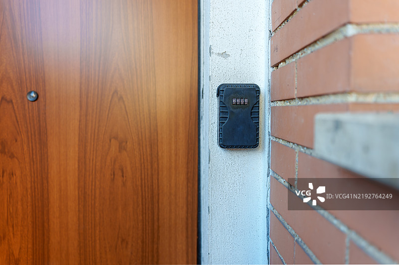 挂在木门旁的钥匙锁箱图片素材