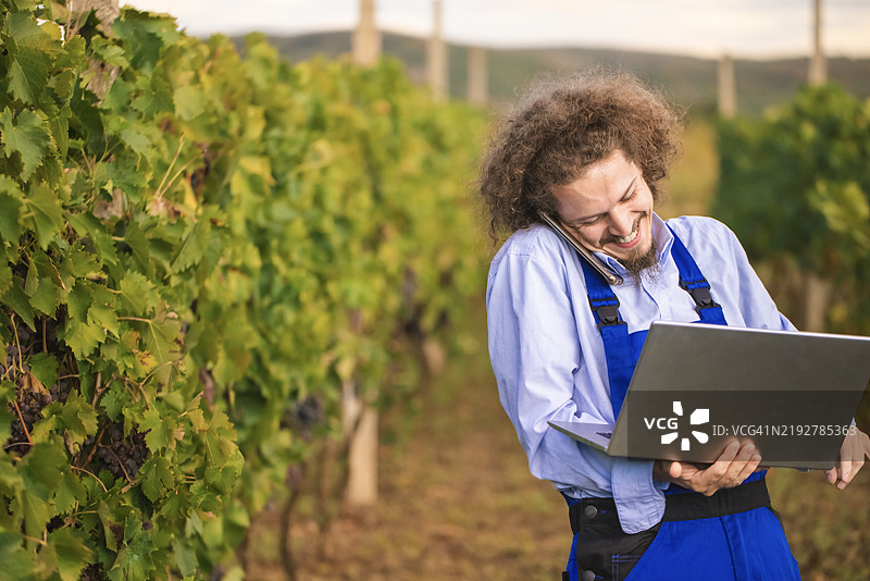 在田野里直接进行视频通话的笑着的农民图片素材