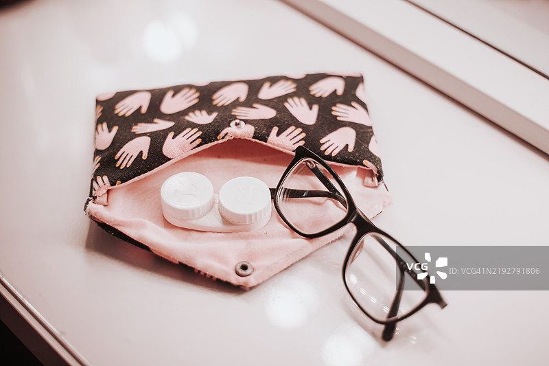 时尚的眼镜盒、一副时尚的眼镜和一套整齐排列的隐形眼镜。图片素材