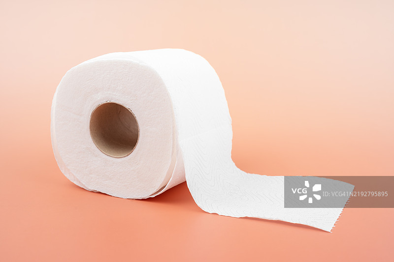 桃色背景上的纸巾卷。图片素材