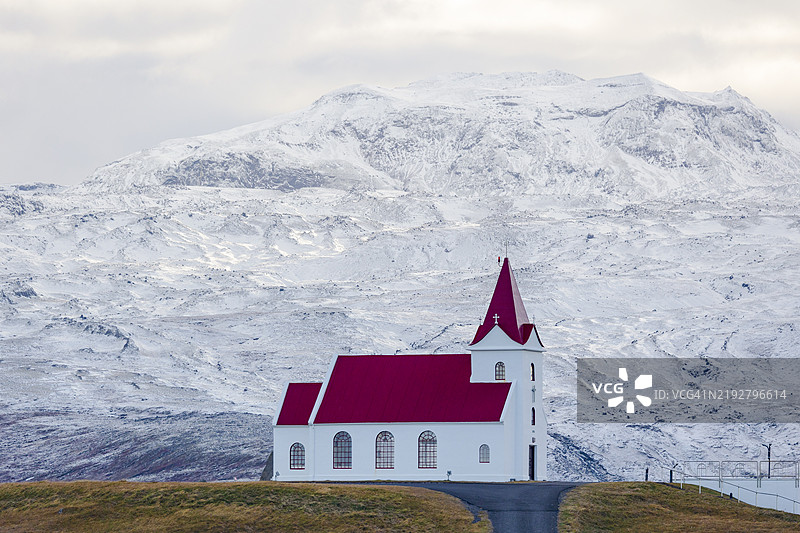 冰岛欧洲的英贾尔德斯霍尔斯基尔基亚美丽教堂，背后是白雪皑皑的山脉。图片素材