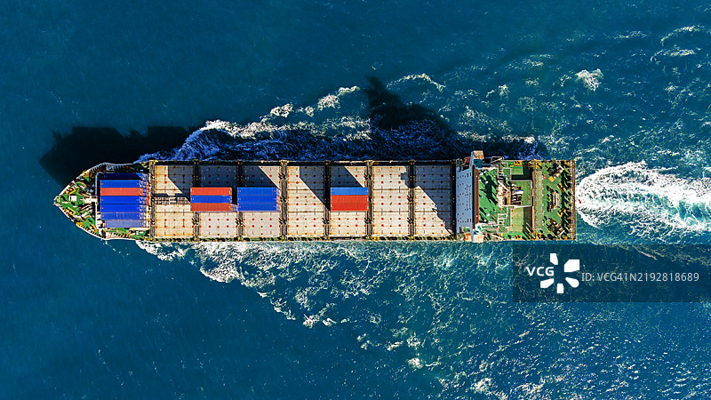 蓝色海洋上方的货柜船鸟瞰图。图片素材