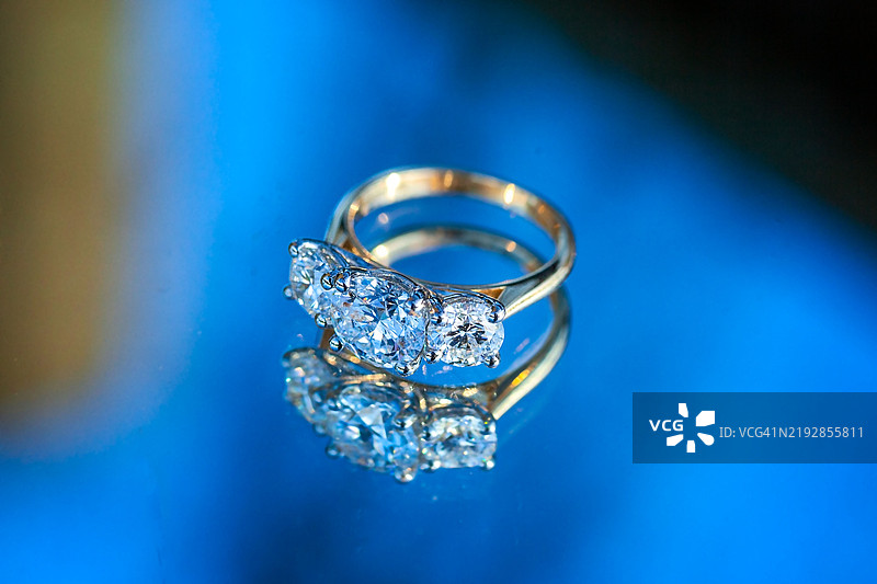 三克拉钻石戒指侧视图，背景为蓝色图片素材