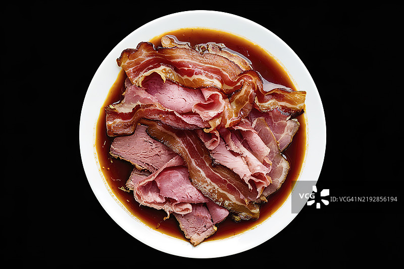一张白色盘子上放着培根块和熏牛肉片的照片图片素材
