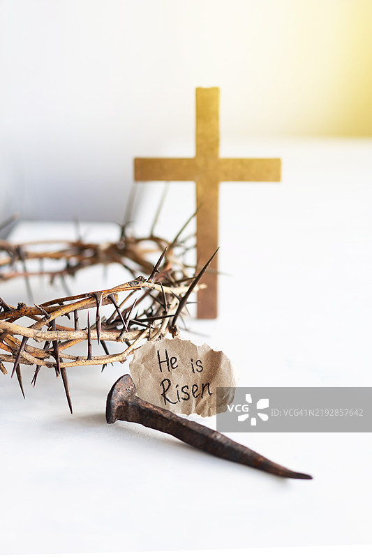 他复活了，耶稣的荆棘冠、钉子和十字架在白色背景上，复活节日。图片素材