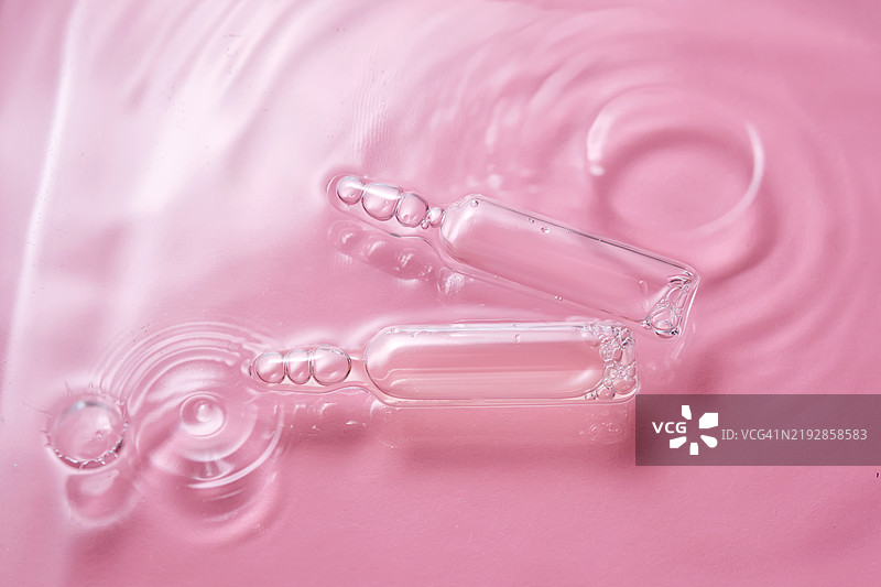 粉色背景上的安瓿瓶与水图片素材