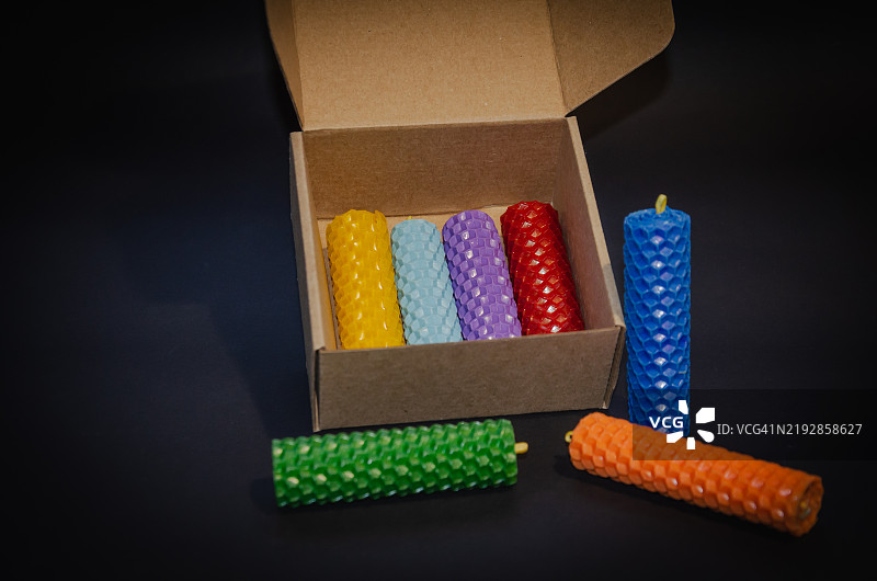 不同颜色的蜡烛在黑色背景上，脉轮蜡烛图片素材