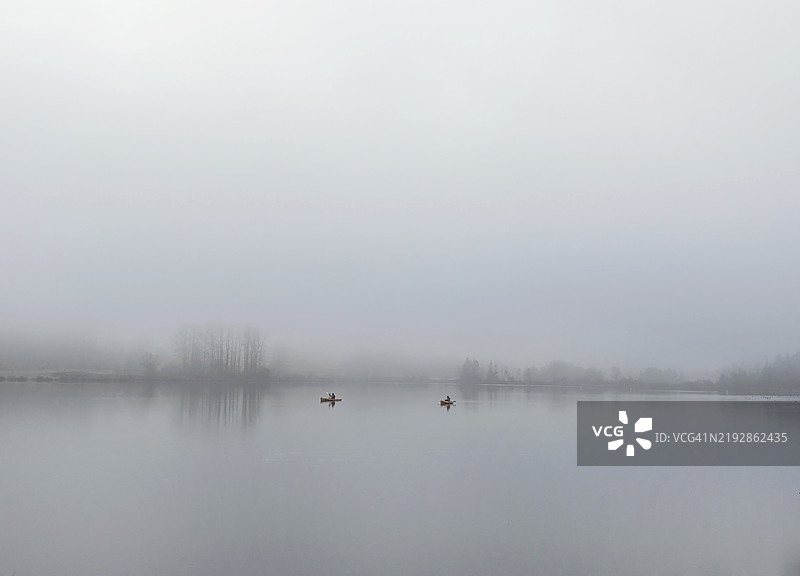 雾气弥漫的湖面上的皮划艇图片素材