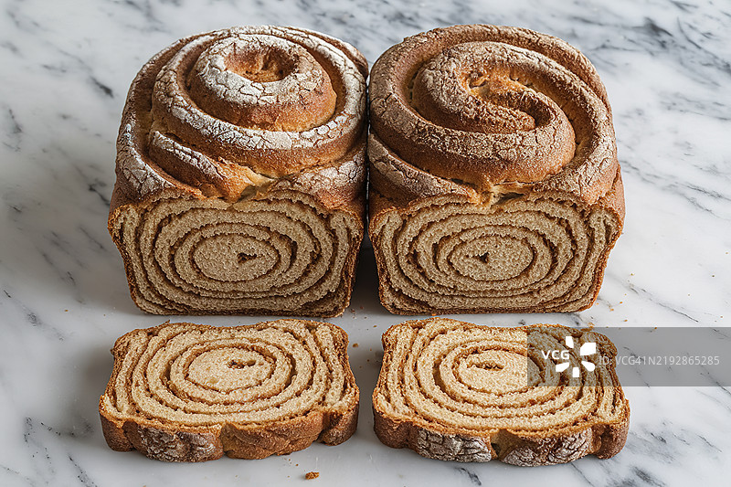 两条面包，上面有旋涡状的肉桂和糖图案图片素材