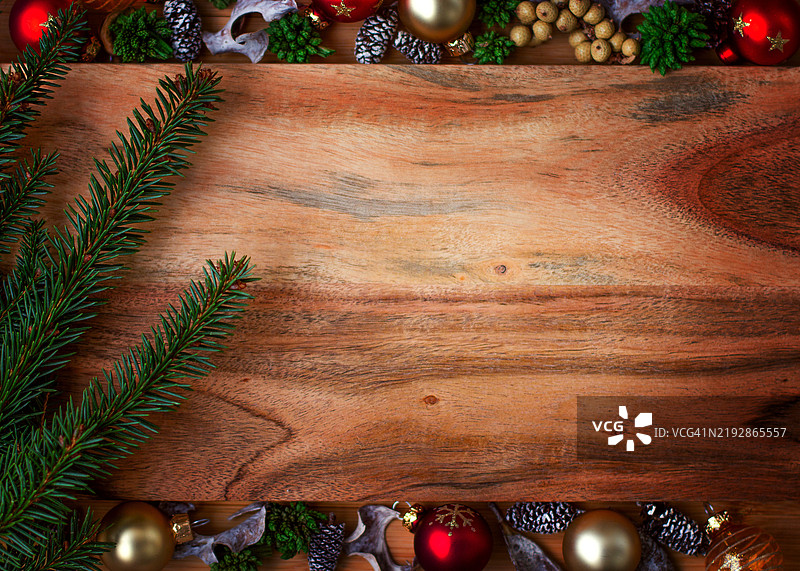由木材制成的新年背景，配有圣诞树枝，并被新年装饰球框住图片素材