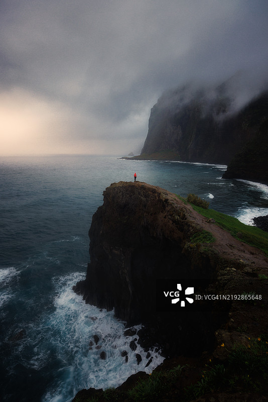 站在悬崖上俯瞰大海的男人图片素材