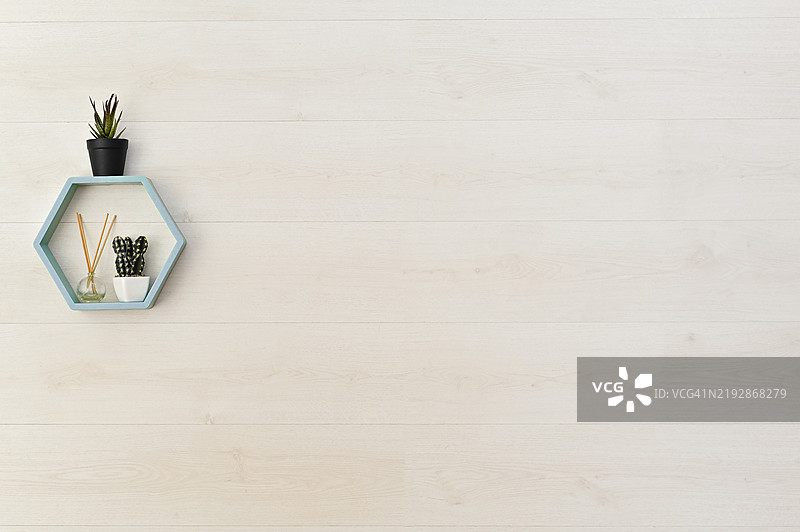 墙上的木架上摆放着花朵和香薰扩散器图片素材