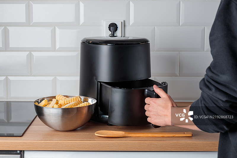 在家中使用时尚厨房小工具空气炸锅烹饪炸土豆，迷你台面对流烤箱，无油深炸，更健康的炸食物烹饪方式图片素材