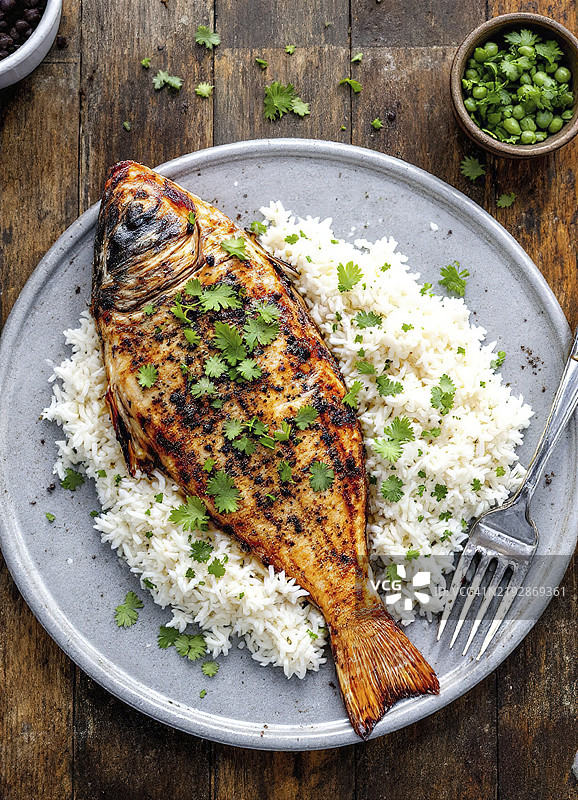 切菜板上的烤鱼和白米饭图片素材