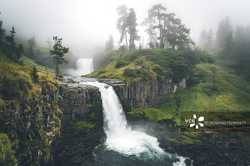 一幅令人惊叹的自然风光照片，展示了一条瀑布从岩石悬崖上倾泻而下。图片素材