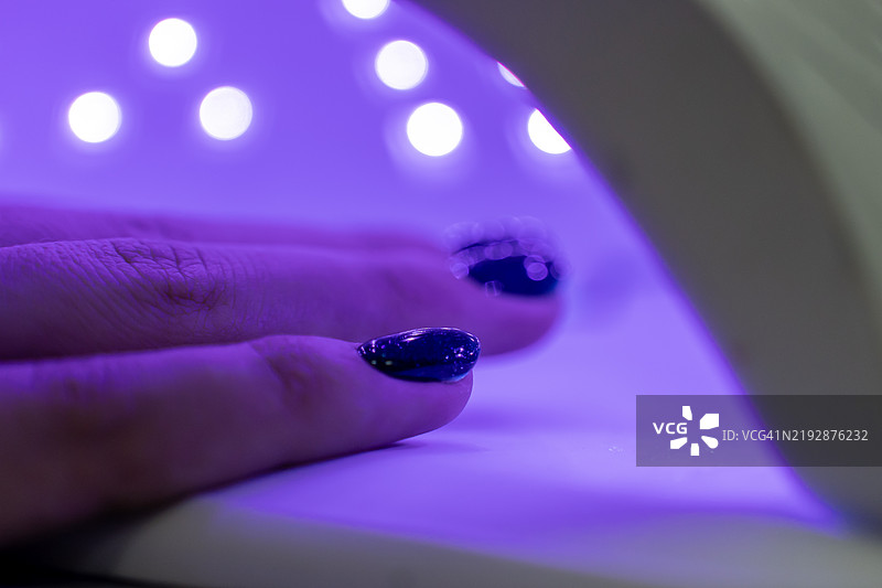女性使用紫外线灯干燥器图片素材