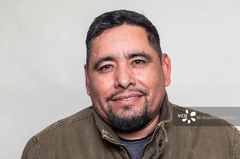 微笑的西班牙裔成熟男性头像，背景为灰色图片素材