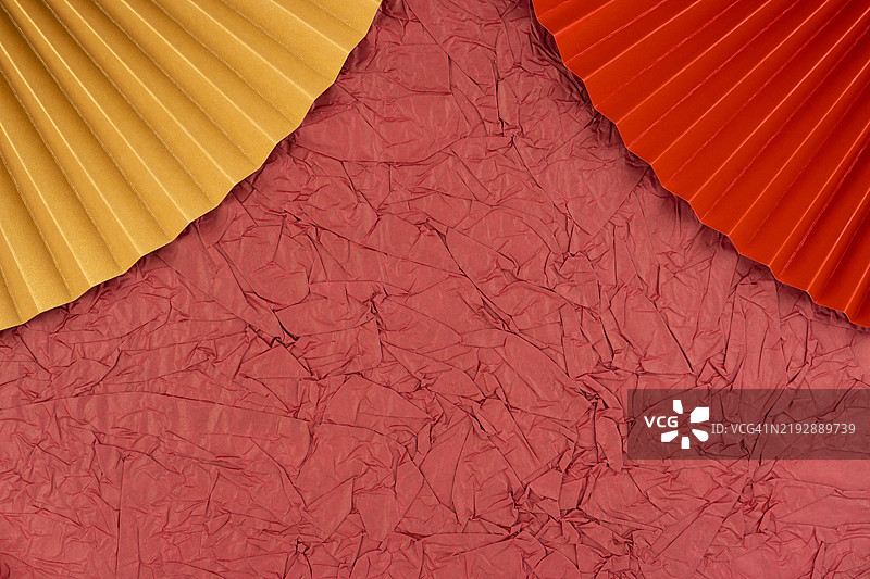 红色背景上的黄色和金色折叠纸，抽象背景。图片素材