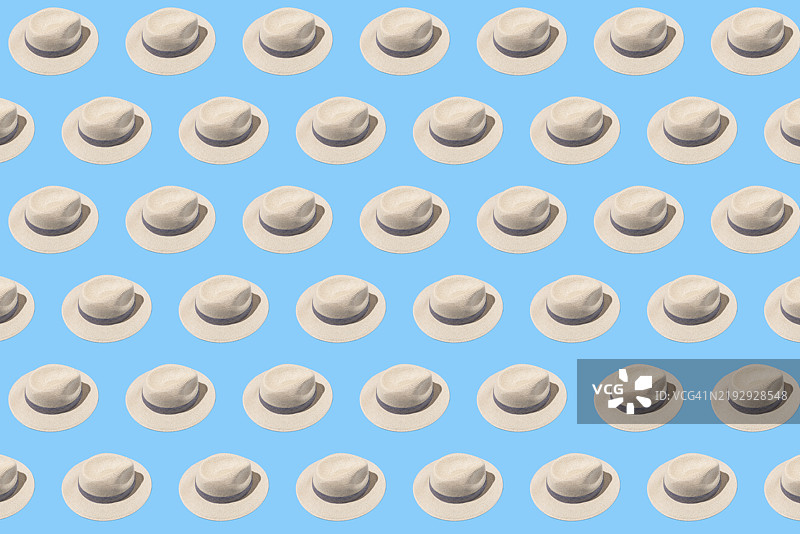 蓝色背景上带有深色丝带的钩针帽子图案。夏季，保护自己，遮阳和防热。图片素材