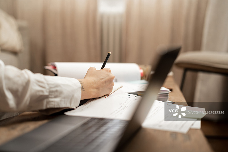 女性自由职业者在家办公室用笔记本电脑写日记图片素材