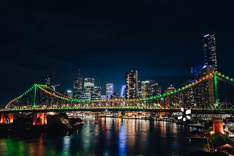 布里斯班河夜景中，中央商务区的摩天大楼与前景的故事桥相映成趣，澳大利亚昆士兰州布里斯班。图片素材