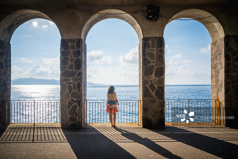 一位女性在意大利卡拉布里亚的海岸公路上欣赏风景图片素材