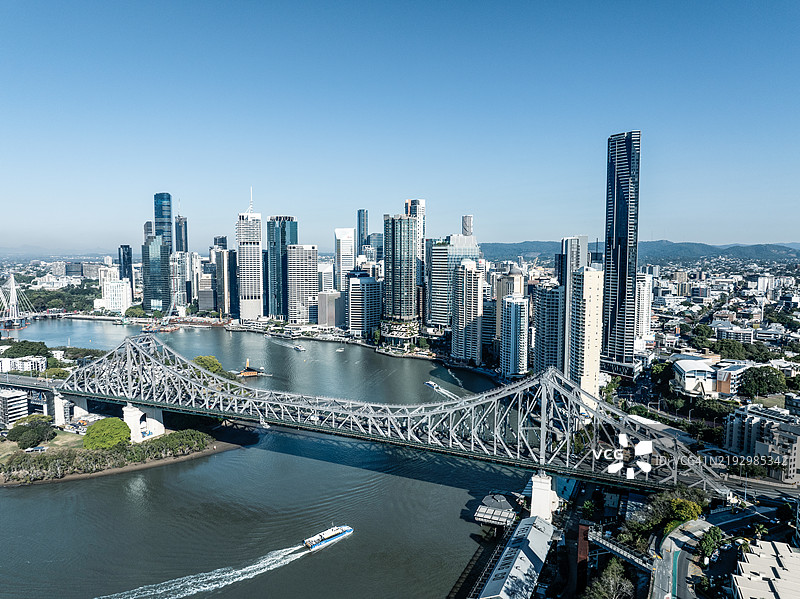 在阳光明媚的日子里,从空中视角拍摄的布里斯班河上,船只经过故事桥,地点:澳大利亚昆士兰州布里斯班。图片素材