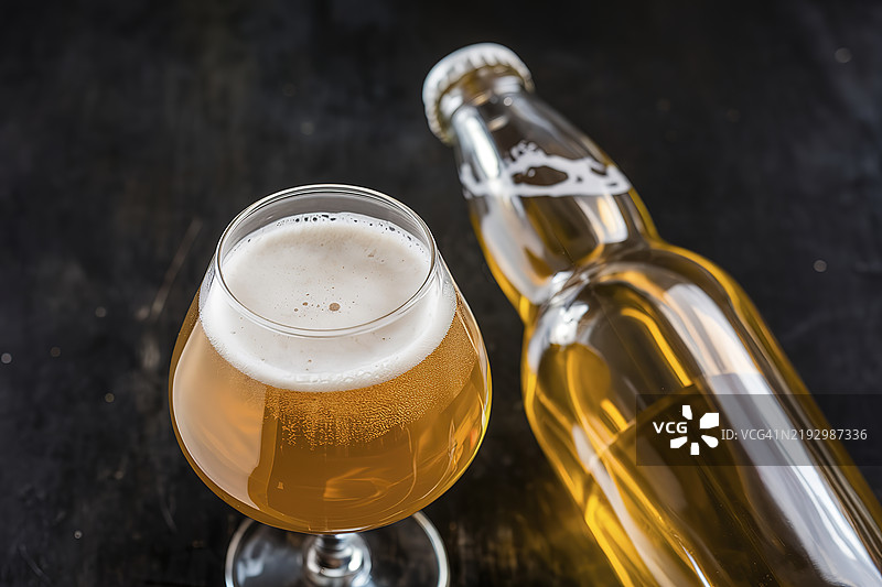 一张清澈的瓶子和一个装有金色啤酒的玻璃的照片图片素材