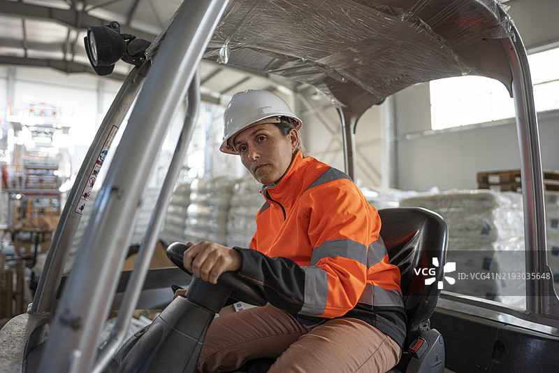 女性在仓库区域驾驶叉车图片素材
