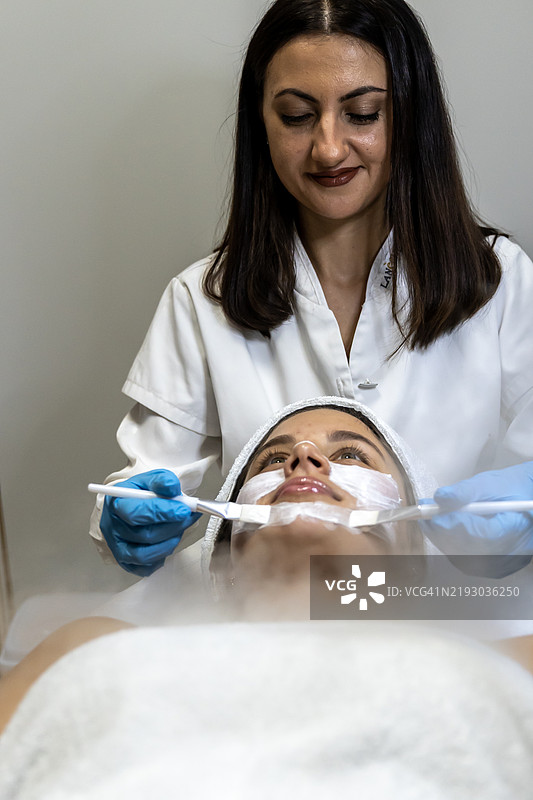 年轻女性正在进行面部美容护理图片素材