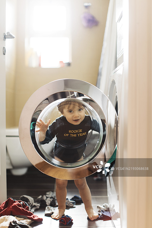 孩子从洗衣机门里玩捉迷藏图片素材