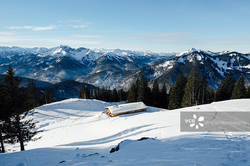 冬季阿尔卑斯山的俯瞰景色，远处有一座小屋图片素材