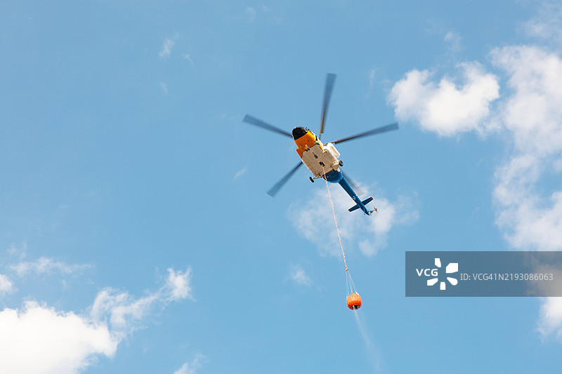 消防直升机在野火中携带水，空中灭火行动图片素材