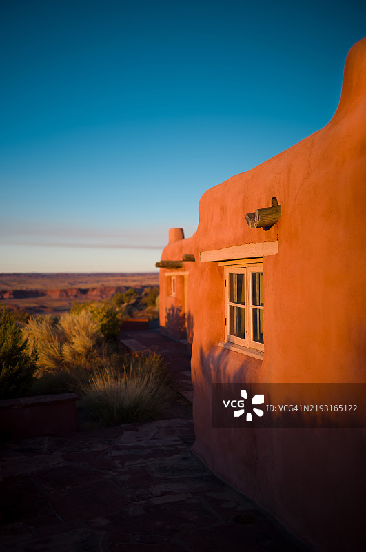 在涂鸦沙漠旅馆的落日，突显互补色彩和普韦布洛复兴风格的建筑，背景是美丽多彩的涂鸦沙漠景观。图片素材
