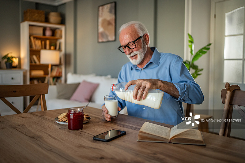 男人享受着美味的早餐，搭配饼干和草莓果酱图片素材