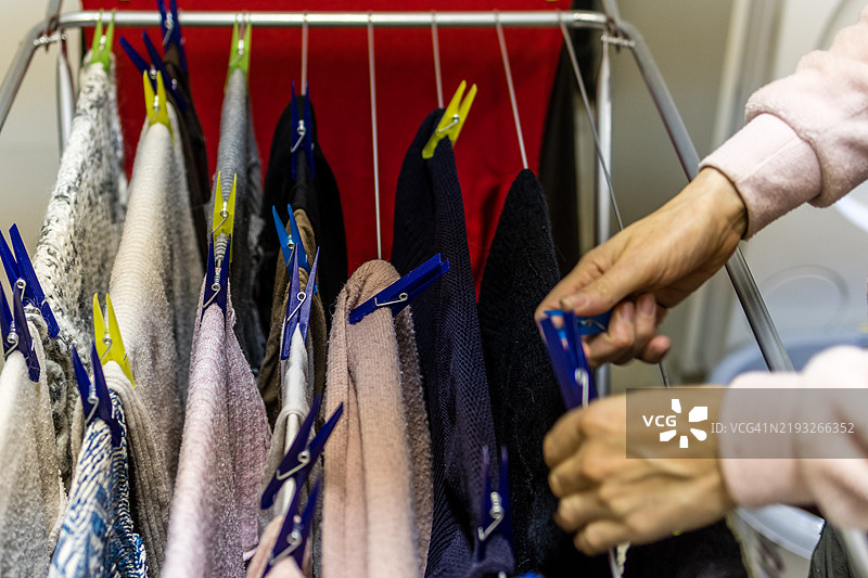 一位老年女性在便携式晾衣架上晾衣服图片素材